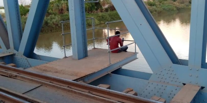 A man sits on Blue Nile Bridge in Khartoum  where several peaceful protesters were killed by security agencies in June 2019
