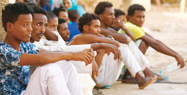 Eritrean migrants sit at the Wadi Sherifay camp on May 2, after being caught by Sudanese border security illegally crossing the Eritrea-Sudan border in the eastern Kassala state. (AFP)